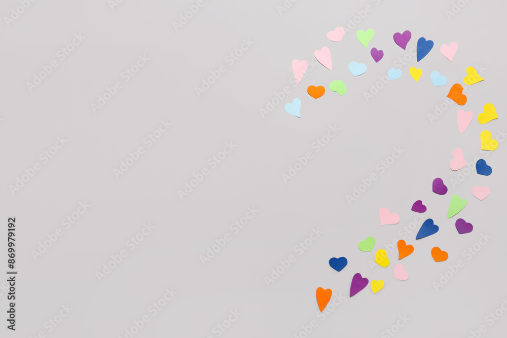 Composition with small colorful paper hearts on grey background. Valentines Day celebration