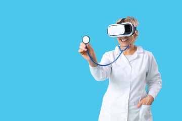 Canvas Print - Mature female doctor with stethoscope using VR glasses on blue background