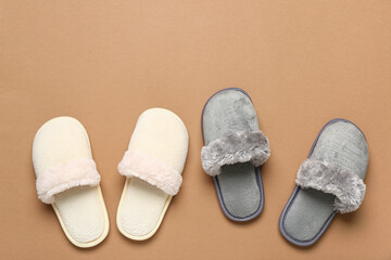 Two pairs of slippers on brown background. Top view