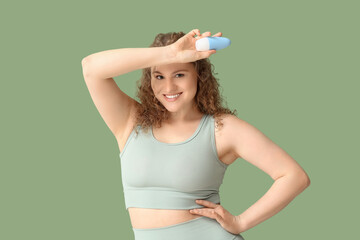 Poster - Happy young woman with deodorant on green background