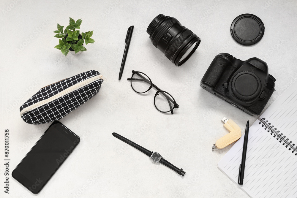 Composition with photographer's equipment, mobile phone and eyeglasses on light background