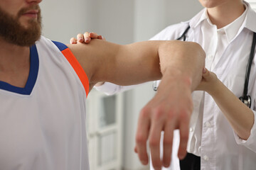 Poster - Sports injury. Doctor examining patient's hand in hospital, closeup