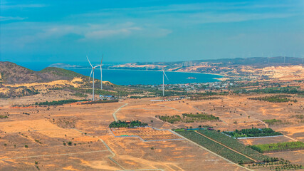 Wall Mural - Panoramic view of wind farm or wind park, with high wind turbines for generation electricity with copy space. Green energy concept. Ocean at Bau Trang, Binh Thuan, Vietnam