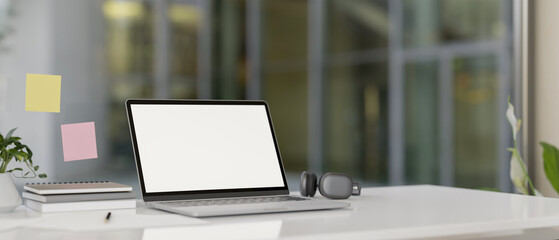 Wall Mural - A modern office features a laptop computer with a white-screen mockup on a white desk.