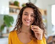 © Khritthithat - Young woman holding a capsule with a smile, focus on health and beauty supplements, bright and airy home