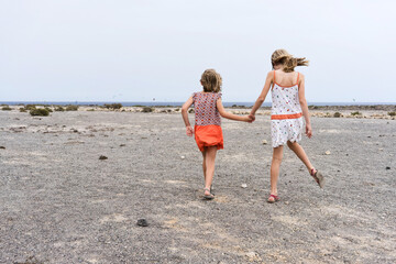 two sisters walking hand 