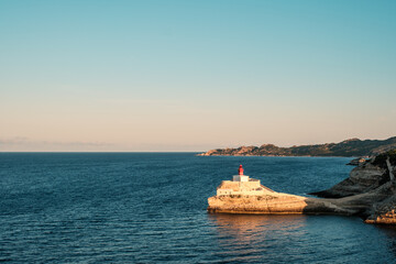 Sticker - Early morning sun on Phare de la Madonetta, a lighthouse on a limestone promontory at the entrance to the harbour at Bonifacio in Corsica