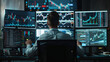 © M - Financial analyst monitoring multiple stock market data on computer screens in a modern office at night