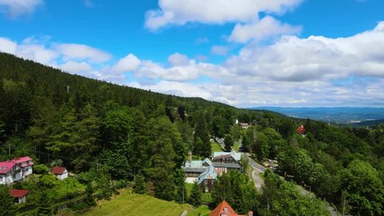 Canvas Print - Aerial view of a village in the mountains forest of Germany on a sunny day