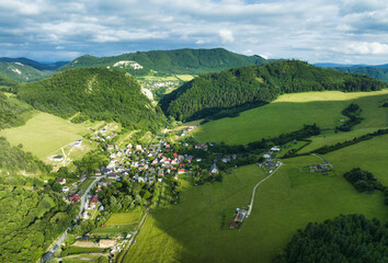 Wall Mural - aerial view of beautiful green hills at sunset. colorful landscape with rural road, trees, grass and