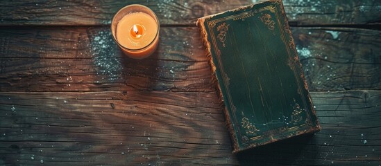 Poster - A vintage magical book and a lit candle sit on a wooden table with a flat lay background, perfect for a copy space image.