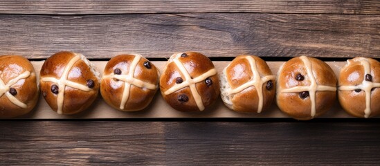 Poster - Easter hot cross buns displayed from above on a wooden background with ample copy space for customization in the image.