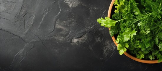 Aufkleber - Top view of salad leaves mixed in a black bowl on a dark slate, stone, or concrete surface, with ample copy space image.