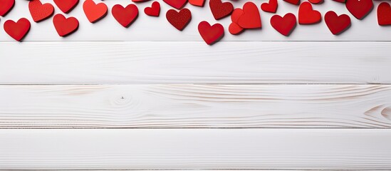 Wall Mural - Valentine's Day concept depicted with red hearts on a white wooden background, suitable for copy space image.