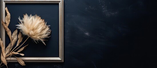 Poster - A white wooden frame with a dried flower against a black textured backdrop creates an elegant copy space image.
