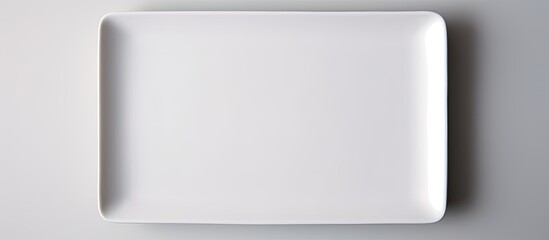 Poster - Rectangular white ceramic plate on a white backdrop with copy space image.