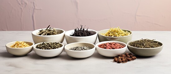 Aufkleber - Various varieties of dried tea presented in white ceramic dishes, accompanied by a cup of fragrant tea, all set against a grey backdrop, ideal for a copy space image.
