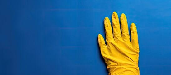 Poster - Blue protective glove on yellow background with copy space image.