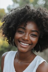 Wall Mural - A woman with curly hair is smiling and wearing a white tank top. She has a gold necklace around her neck