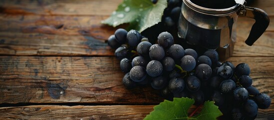 Poster - Black grapes on a wooden table with space for text, next to a coffee percolator. copy space available