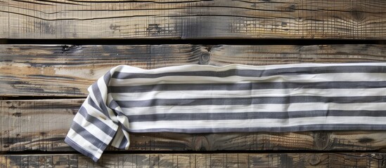 Poster - Top view of a striped napkin laid on a wooden surface with copy space image.