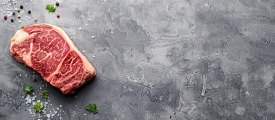 Poster - Top view of Japanese wagyu rib eye steak on a gray background, with a spacious copy space image.