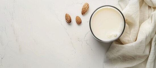 Aufkleber - Almond-based alternative milk in an unpeeled glass placed on a white table viewed from above with copy space image.