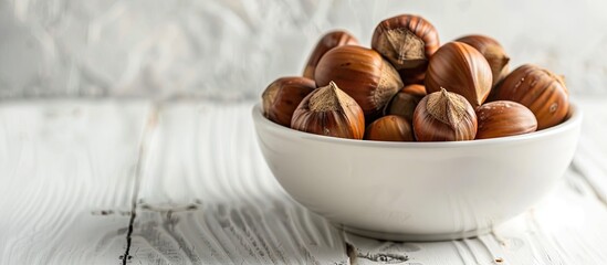 Poster - Selective focus on a bowl of freshly boiled chestnuts on a white wooden table with room for text or other elements in the image. copy space available
