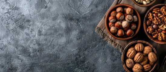 Poster - Top view of different types of nuts placed in wooden bowls against a copy space image.