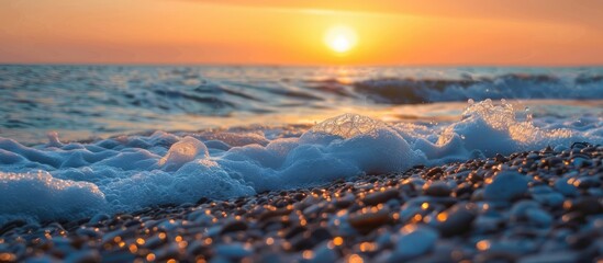 Poster - sunset scenery by the pebble beach with waves crashing on shore, ideal for use as a copy space image