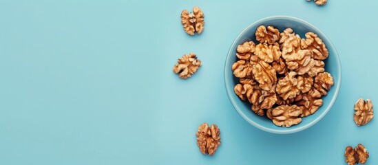 Poster - High angle view of a walnut snack on a blue backdrop with copy space image.