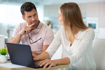 Wall Mural - happy couple at home paying bills with laptop