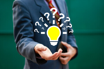 Question mark concept. Problem and solution. Quiz, test, survey, support, knowledge, decision and idea. Businessman holding light bulb with question mark icon on virtual screen for FAQ.