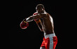 © master1305 - Strong and focused boxing athlete in motion, punching, fighting shirtless in boxing ring isolated on black background. Concept of professional sport, active lifestyle, body, strength