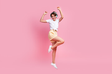 Canvas Print - Full view shot of attractive youth girl listening her favorite retro music use modern headphones jumping isolated on pink color background