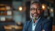© armensl - businessman corporate portrait in office, mature black middle aged manager business man. Portrait of happy african man wearing spectacles and looking at camera.