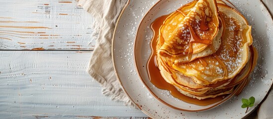 Poster - Close-up of delicious homemade caramel stuffed pancakes on a white wooden background with selective focus, top view, and spacious area for text or images - a great copy space image.