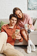 © Bliss - A young couple relaxes at home, with the womans prosthetic leg while her boyfriend is on his phone.