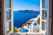 © Ismah Yuni - View from an open window with blue shutters of the Aegean sea, caldera, coastline and whitewashed town of Oia, Santorini, Greece