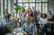 © SnapVault - A diverse and multi-ethnic group of happy people in a modern office setting. coworkers are gathered around desks, conveying teamwork and positive work environment.