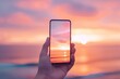 © Shining Pro - A person is holding a cell phone up to their eye, capturing a beautiful sunset