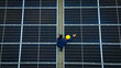 © tong2530 - An engineer meticulously inspects solar panels on a rooftop, ensuring optimal performance under the clear blue sky. Top view