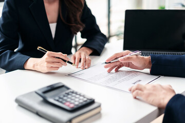 Two people are sitting at a table with a piece of paper in front of them