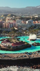 Wall Mural - Aerial view of Puerto de la Cruz cityscape at sunrise, Tenerife, Spain. Purto de la Cruz town with Teide volcano at background on Tenerife, Canary islands. Swimming pool complex and waterfront
