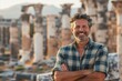 © CogniLens - Portrait of a happy man in his 40s dressed in a relaxed flannel shirt on backdrop of ancient ruins
