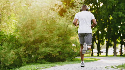 Wall Mural - Athletic African American Guy Running In The Park, rear view, copy space