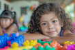 © smth.design - Happy Child with Curly Hair Playing with Colorful Building Blocks at Daycare