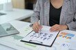 © Parichat - Business Professional Analyzing Financial Charts and Graphs in Modern Office Setting
