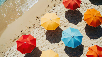 Wall Mural - Colorful umbrellas dot the sandy shore, casting shade from the summer sun.