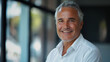 © vitor - Feliz homem de negócios de meia idade mais velho executivo em pé no escritório. Sorrindo 50 anos maduro confiante profissional gerente